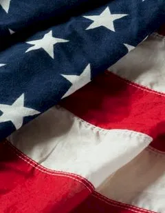 A close-up of a red, white, and blue American flag with white stars on blue and red/white stripes.